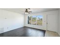 Bright living room with dark hardwood floors, a large window, and white walls at 8003 Herbison Ave, North Port, FL 34287