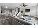 Open-concept living room with modern furnishings, sleek gray floors, and adjacent dining area at 8850 Christie Dr, Largo, FL 33771