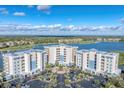 Scenic aerial shot of condo buildings with a pool, surrounded by lush landscaping, near a lake and a golf course at 10520 Boardwalk Loop # 504, Lakewood Ranch, FL 34202