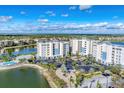 An aerial view showcasing a condo community with a pool, a well-kept landscape, and convenient parking by a lake at 10520 Boardwalk Loop # 504, Lakewood Ranch, FL 34202
