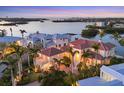 Aerial view of luxury waterfront homes, including tile roofs, surrounded by lush tropical landscaping and the bay at 1137 N Lake Shore Dr, Sarasota, FL 34231