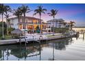 Waterfront home with a private dock, swimming pool, backyard patio, and lush landscaping along the canal at 1137 N Lake Shore Dr, Sarasota, FL 34231