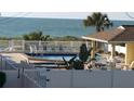 Inviting community pool and hot tub area with ample seating for relaxation at 1300 Gulf Blvd # 202, Indian Rocks Beach, FL 33785
