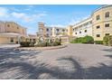 Beautiful building exterior with a circular driveway, fountain, tile roof, and a neutral color palette at 14021 Bellagio Way # 309, Osprey, FL 34229