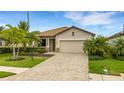 Inviting single-story house shows a tile roof, paver driveway, tropical landscaping, and a two-car garage at 17234 Blue Ridge Pl, Bradenton, FL 34211