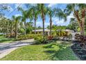 The home features lush landscaping, a verdant lawn, and a patterned brick driveway at 1766 Shoreland Dr, Sarasota, FL 34239