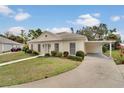 Street view of a single-story home with a covered carport, manicured lawn, and charming curb appeal at 2 Antigua Cir # 4, Englewood, FL 34223