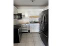 Functional kitchen with ample white cabinetry, stainless steel appliances, and tile floors at 216 Amherst Ave # 97, Sarasota, FL 34232