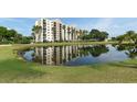Scenic view of a resort-style building reflected in a pond, surrounded by lush greenery and palm trees at 2320 Terra Ceia Bay Blvd # 808, Palmetto, FL 34221