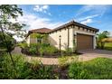 Well-manicured lawn with palm trees and landscaping leading up to the home at 3008 Tolmino Ct, Lakewood Ranch, FL 34211