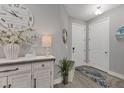 Bright foyer with a decorative table, white accents, wood-look tile, and a round mirror at 3645 Tin Cup Blvd, Sarasota, FL 34232
