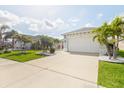 Charming single-story home with well-manicured lawn, palm trees, and a two-car garage at 3711 Manorwood Loop, Parrish, FL 34219