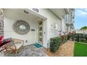 Inviting townhome entrance with decorative mirror, stylish seating, and well-manicured greenery at 512 Laurel Park Dr, Sarasota, FL 34236
