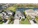 Single-Gathering home with a screened in lanai that overlooks a pond, lush landscaping, and a two car garage at 6161 Anise Dr, Sarasota, FL 34238