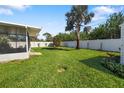 Expansive backyard featuring a tall palm tree and well-maintained lawn, perfect for outdoor activities and relaxation at 6320 Tilly St, Englewood, FL 34224