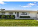 Inviting home exterior with manicured front lawn and attached garage at 6320 Tilly St, Englewood, FL 34224