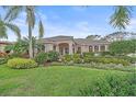 Inviting single-story home featuring a manicured lawn, lush tropical landscaping and a tile roof at 6617 Nautical Dr, Lakewood Ranch, FL 34202