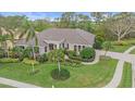 Beautiful single-story home featuring a lush lawn, tropical landscaping, tile roof, and paver driveway at 6617 Nautical Dr, Lakewood Ranch, FL 34202