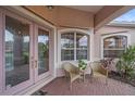 Charming front porch with pink door, wicker chairs, and a view of lush landscaping at 6617 Nautical Dr, Lakewood Ranch, FL 34202
