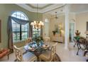 Dining area showcasing a chandelier, round table set, and large window with natural light, creating a comfortable space at 7141 Whitemarsh Cir, Lakewood Ranch, FL 34202
