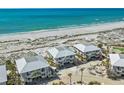Beautiful aerial view of beach homes with balconies overlooking the white sand and ocean at 7490 Palm Island Dr # 2324, Placida, FL 33946