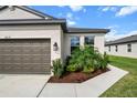 Close-up of home's elevation and landscaping with green shrubs near windows and mulched flower beds at 8619 Firefly Pl, Parrish, FL 34219