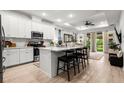 Bright, modern kitchen with white cabinets, stainless steel appliances, and a large center island at 8619 Firefly Pl, Parrish, FL 34219