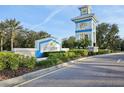 Grand Palm community entrance with a tower, landscaping, and clear signage at 1604 Still River Dr, Venice, FL 34293