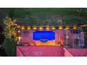 Overhead shot of a screened-in pool at night with illuminated landscaping at 181 Portofino Dr, North Venice, FL 34275