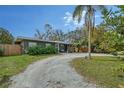 Beautiful single-story home featuring manicured landscaping and a gravel driveway leading to the entrance at 2130 Temple St, Sarasota, FL 34239