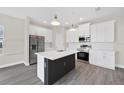 Modern kitchen with a large island, quartz countertops, stainless steel appliances, and bright pendant lighting at 2370 Allsup Ter, North Port, FL 34286