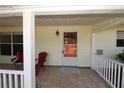 Inviting front porch with tile flooring, seating, and a freshly painted entrance door at 2696 Loma Linda St, Sarasota, FL 34239