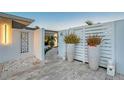 Entrance way to home with large potted plants and a brick-paved walkway at 309 Avenida Milano, Sarasota, FL 34242