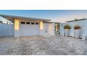 Garage with a paved driveway and decorative accents; enhanced by landscape lighting at 309 Avenida Milano, Sarasota, FL 34242