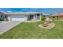 Well-maintained single-story home with attached garage, landscaping and a sprawling green lawn at 3335 Brooklyn Ave, Port Charlotte, FL 33952