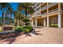 Elegant building entrance with lush landscaping and brick driveway showcasing luxury residences at 35 Watergate Dr # 1101, Sarasota, FL 34236