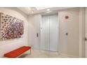 Modern lobby featuring an elevator, artistic decor, and a comfortable orange bench at 35 Watergate Dr # 1101, Sarasota, FL 34236