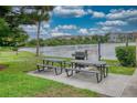 Outdoor grilling area with two picnic tables, barbeque grill, and water views at 3658 Lake Bayshore Dr # 320, Bradenton, FL 34205