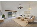 Bright living room with a ceiling fan, tan couch, wicker chair and a sliding door that allows natural light to brighten the room at 3902 36Th Avenue W Dr, Bradenton, FL 34205
