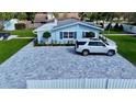 Wide shot of a home's driveway, showing a parked car on a patterned brick surface, and lawn at 4218 S Lockwood Ridge Rd, Sarasota, FL 34231