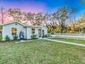 Inviting single-story home with blue hanging chair and a white picket fence, enhanced by lush landscaping at 425 Bristol Ct, Sarasota, FL 34237