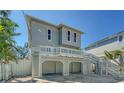 Angle view of two-story beach home featuring elevated deck and covered parking at 462 Island Cir, Sarasota, FL 34242