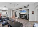 Open-concept living area with wood floors, decor shelving and modern ceiling fan at 5003 88Th E St, Bradenton, FL 34211
