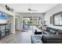 Bright living room featuring wood floors, fan and large sliding glass doors to a screened patio at 5003 88Th E St, Bradenton, FL 34211