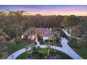 Stunning aerial shot showcases this property’s circular driveway, gorgeous landscaping, and mature surrounding trees at 5416 Ashley Pkwy, Sarasota, FL 34241