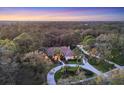 Expansive aerial view of a beautiful estate home surrounded by lush forest and meticulously maintained landscaping at 5416 Ashley Pkwy, Sarasota, FL 34241