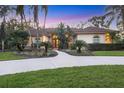 Beautiful home displaying a manicured front lawn, mature palms, and a lovely walkway leading to the entryway at 5416 Ashley Pkwy, Sarasota, FL 34241