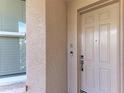 Apartment 403 front door with doorbell on beige stucco exterior at 5591 Cannes Cir # 403, Sarasota, FL 34231