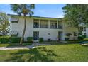 Charming condo exterior featuring a covered porch, verdant landscaping, and a brick walkway at 5665 Midnight Pass Rd # 410, Sarasota, FL 34242