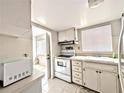 Traditional kitchen with white cabinets, tile backsplash, and a view to the entry door at 5904 Palm Ln # C23, Bradenton, FL 34207